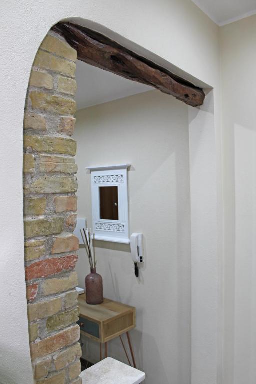 Pokój z ceglaną ścianą i lustrem w obiekcie Flamingo Luxury Apartment AJPSARDINIA w Cagliari
