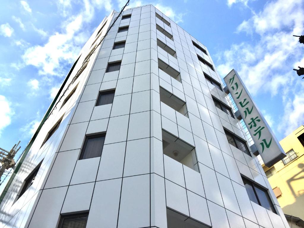 een hoog wit gebouw met een bord erop bij Green Hill Hotel Tennoji Ekimae in Osaka