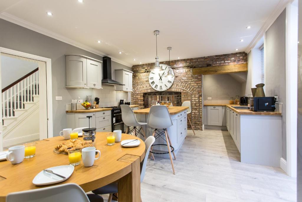 a kitchen and dining room with a table and a clock at Augustus House in Chester