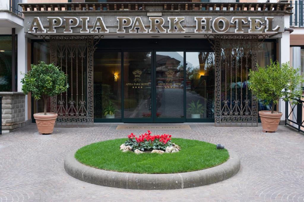 a large building with a large flower garden in front of it at Appia Park Hotel in Rome