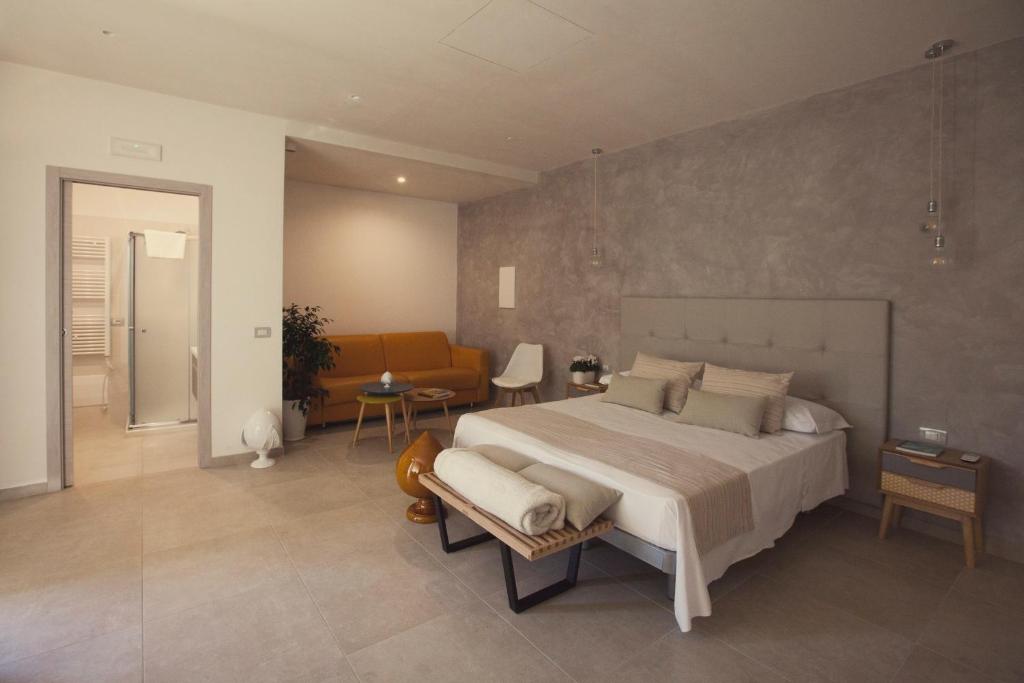 a hotel room with a bed, chair, and table at Avantgarde Hotel in Conversano