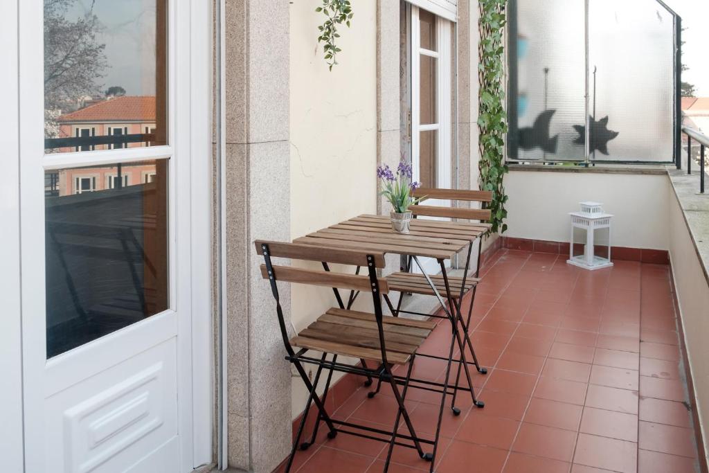 ポルトにあるapartment with balcony in the squareの木製テーブルと椅子付きのバルコニー