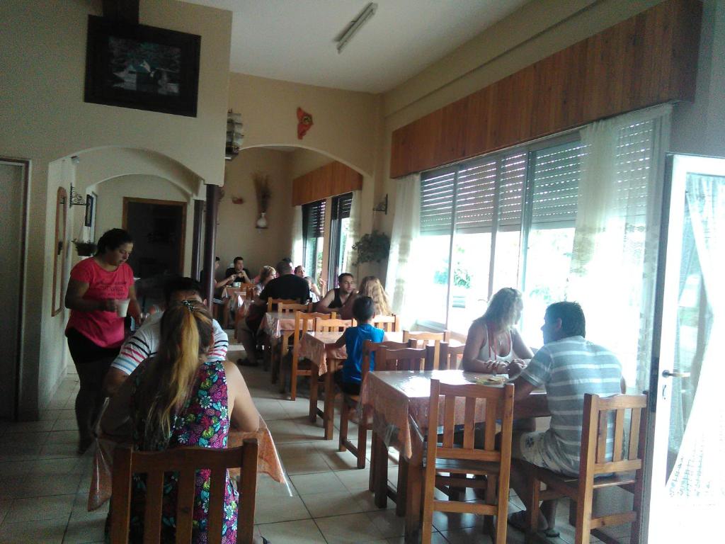 un grupo de personas sentadas en las mesas de un restaurante del Hotel Molise de Villa Gesell
