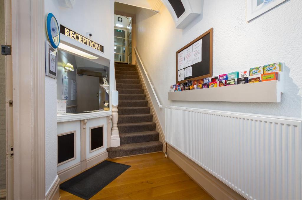 a hallway with a staircase with a stair case at Maples Hotel in Blackpool