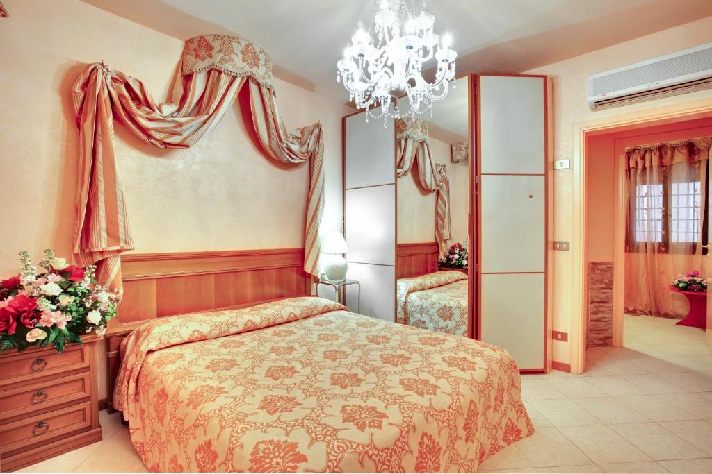 - une chambre avec un lit et un lustre dans l'établissement Antico Fiore Apartments, à Venise