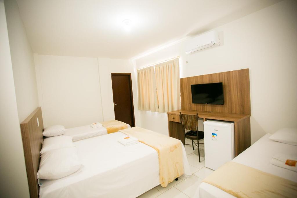 a hotel room with two beds and a television at Hotel Folley in Toledo