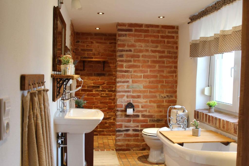 a bathroom with a white sink and a brick wall at Haus62 in Weißwasser