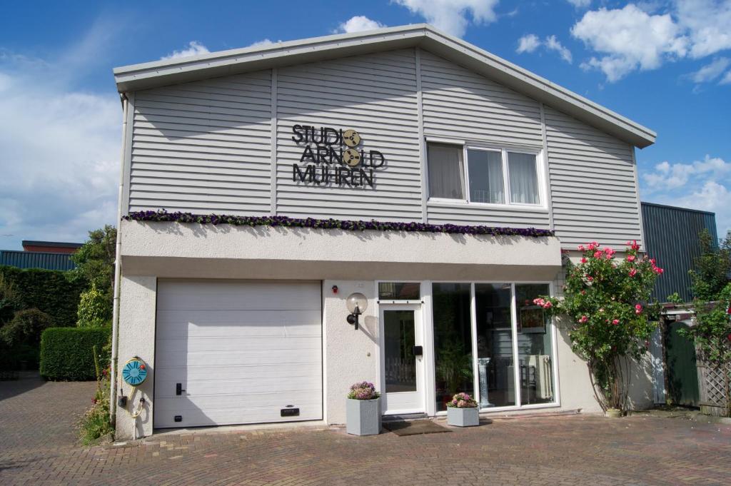 a small white building with a garage at The Studio Guesthouse in Volendam