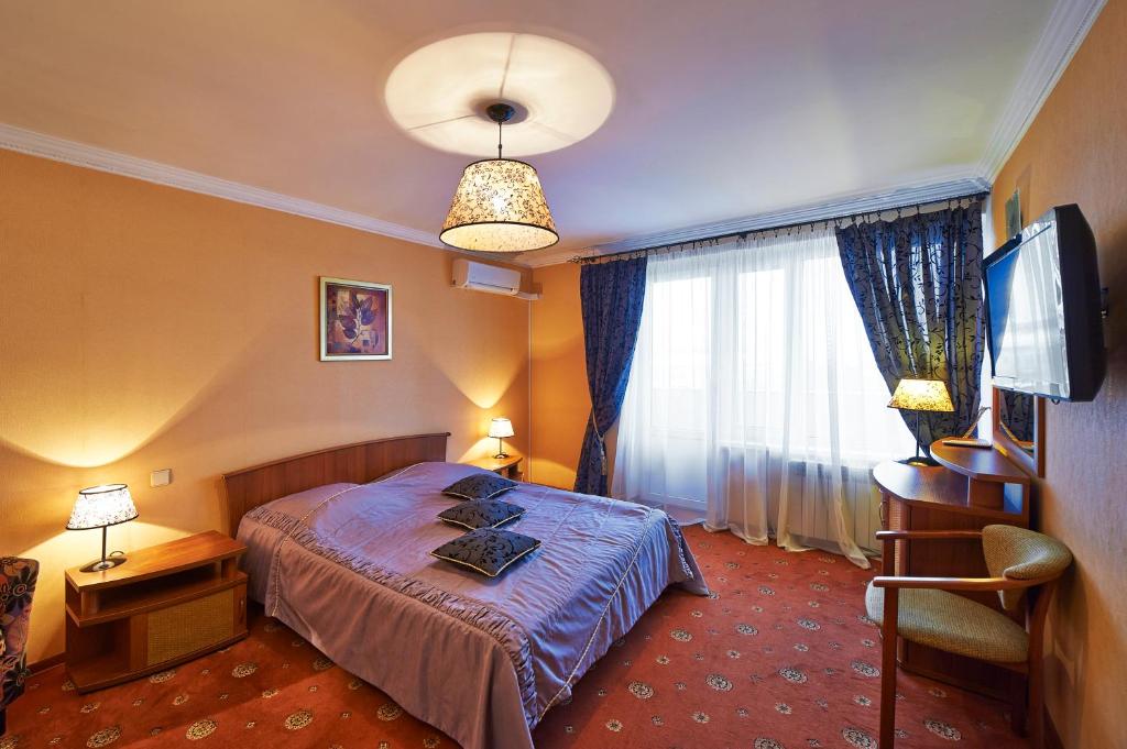 a hotel room with a bed and a window at Hotel Moskvich in Moscow