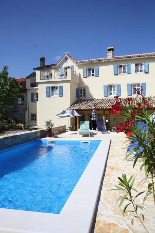 a villa with a swimming pool in front of a building at Terra Mirna - Urlaub für die Sinne in Vižinada