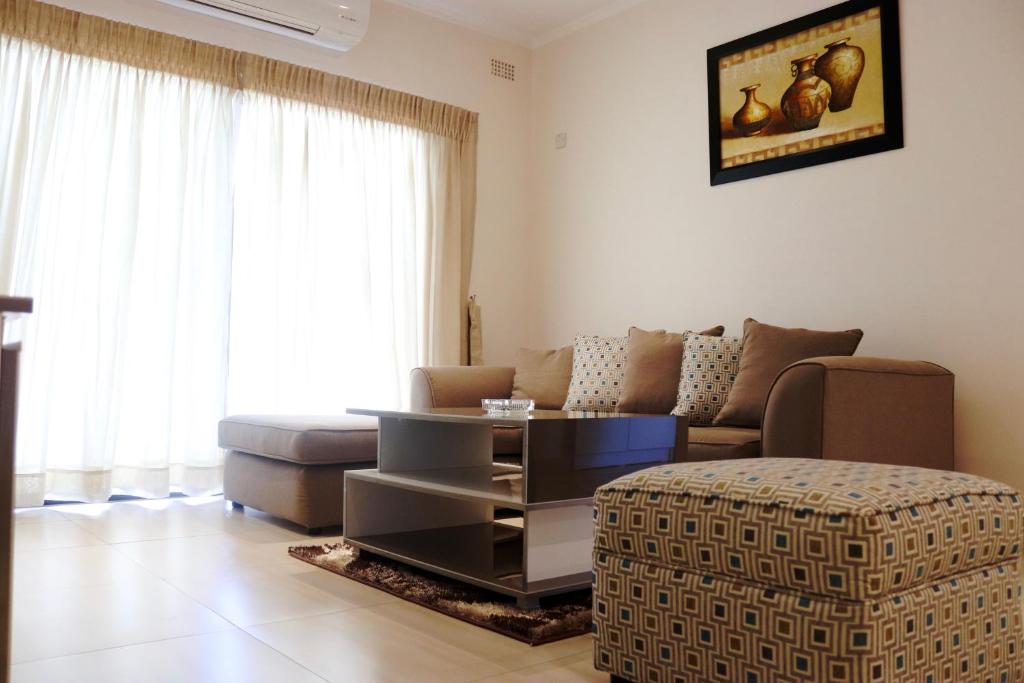 uma sala de estar com um sofá e uma mesa em AMB Apartments em Lusaka