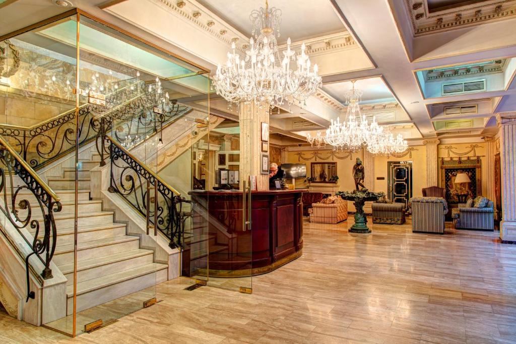 a large lobby with a staircase and chandeliers at Author Boutique Hotel (ex Golden Garden Boutique Hotel) in Saint Petersburg