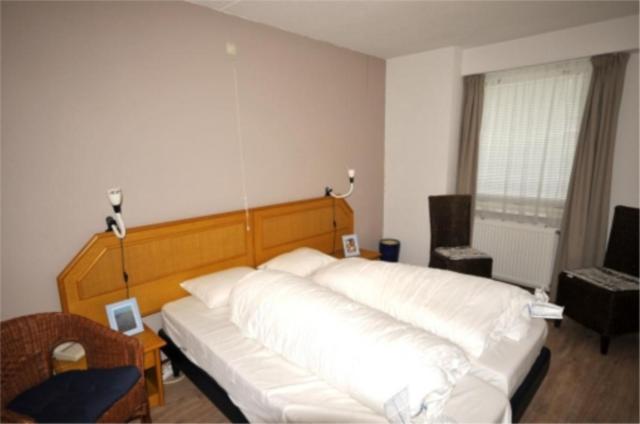 een slaapkamer met een groot wit bed in een kamer bij Appartement 121 in Julianadorp