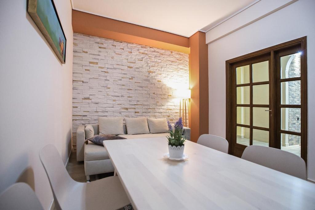 a dining room with a white table and chairs at Paradise Apartment in Peiraiki in Piraeus