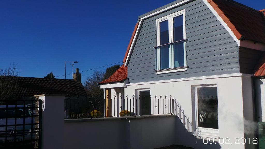 Casa blanca con ventana y valla en The Smithy en Largoward