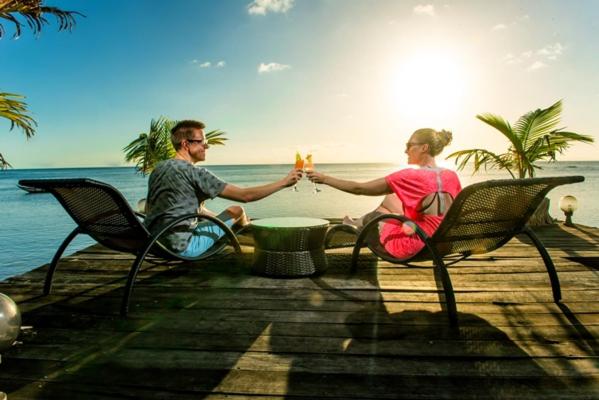 un homme et une femme assis sur des chaises avec des boissons dans l'établissement Hotel Vanivola, sur l'île Sainte-Marie