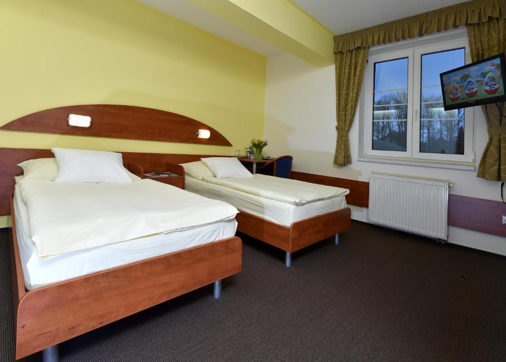 Postel nebo postele na pokoji v ubytování Hotel Břízky