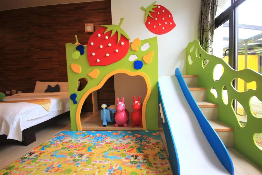 a childrens bedroom with a play area with a bed and strawberries at Yudo B&amp;B Yilan in Dongshan