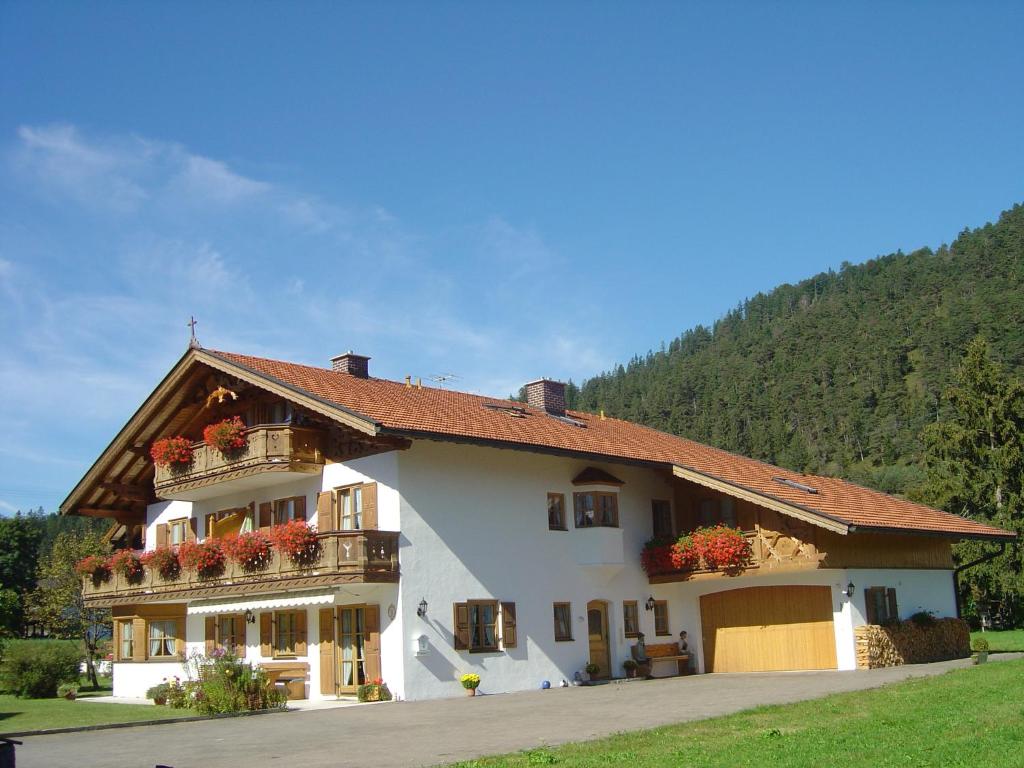 un grande edificio bianco con fioriere sopra di Gästehaus Anneliese a Wallgau