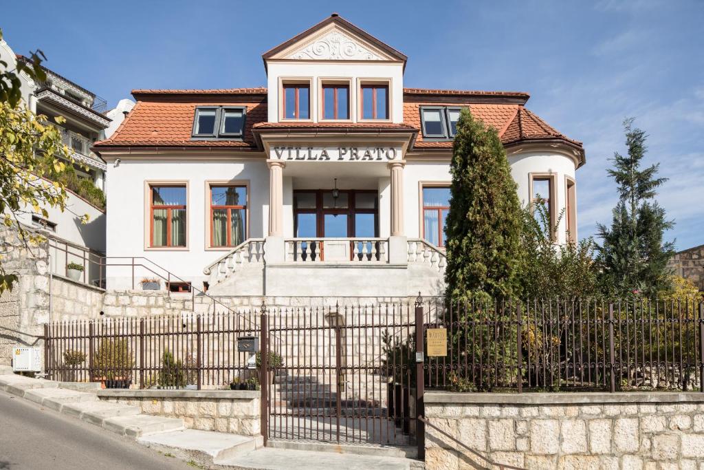 una casa bianca con una recinzione di fronte di Villa Prato a Braşov