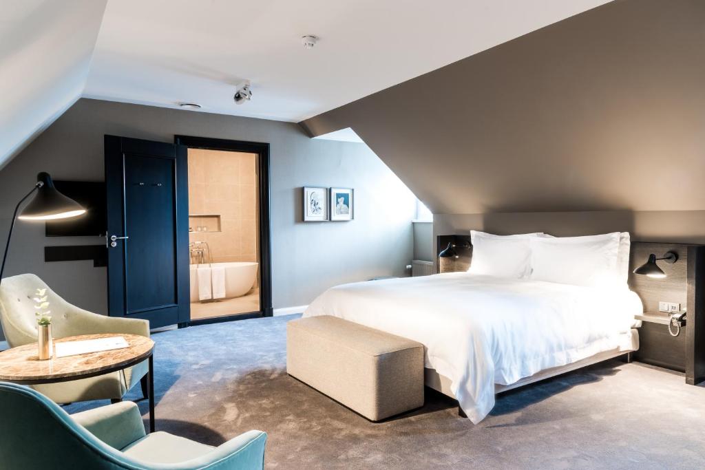 een slaapkamer met een groot bed en een tafel en stoelen bij Pillows Grand Boutique Hotel Ter Borch Zwolle in Zwolle