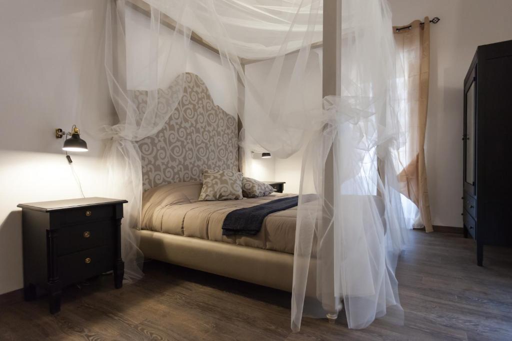a bedroom with a bed with a canopy and a nightstand at Your Apartment in Il-Furjana