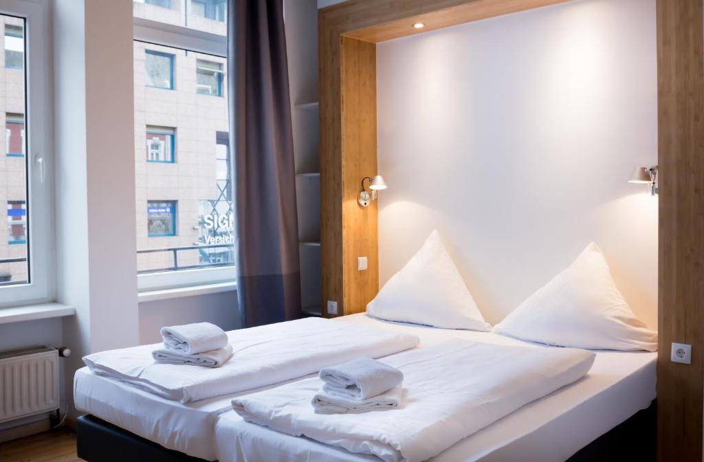 a hotel room with two beds and a window at dingdong koblenz - city apartments in Koblenz