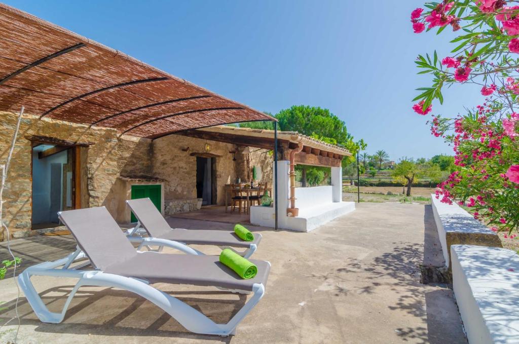 patio z 2 leżakami i budynkiem w obiekcie Sa Rota (Den Joan Porrerenc) w mieście Montuiri