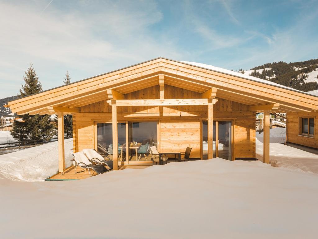 eine Blockhütte im Schnee in der Unterkunft Chavida Chalets in Schattwald