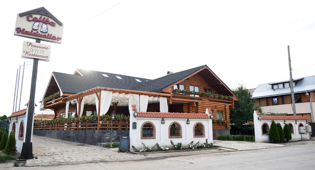 ein großes Holzgebäude mit einem Schild davor in der Unterkunft Domeniul Haiducilor Bucovina in Suceava