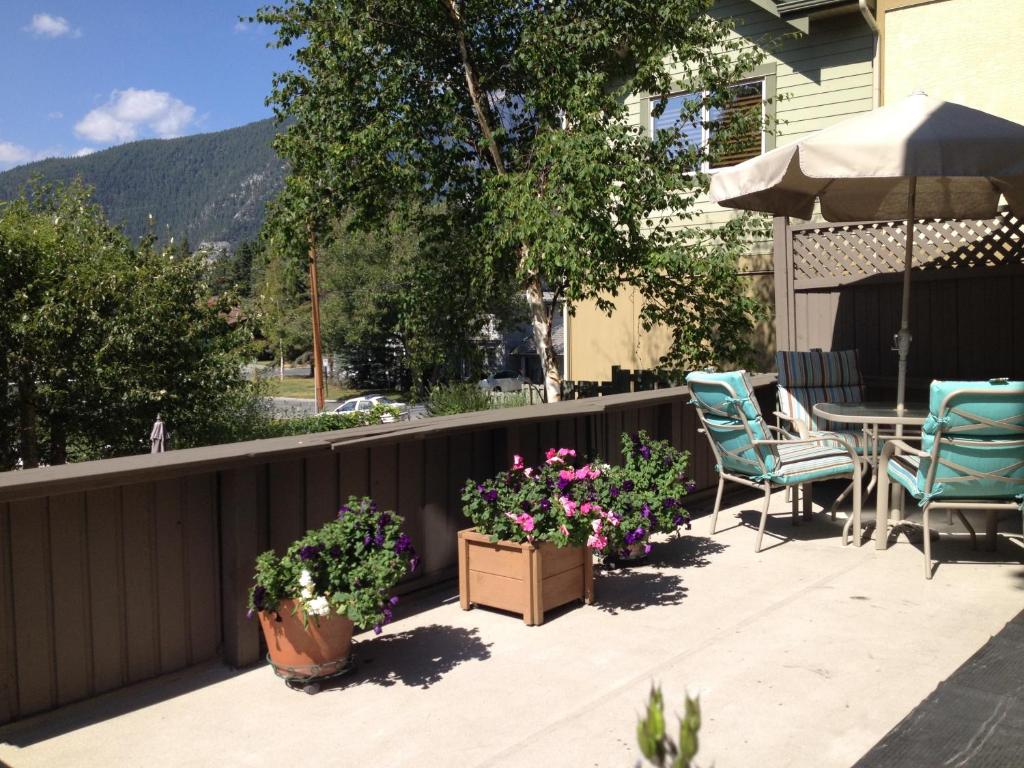 a patio with two chairs and a table and some flowers at Mountain View Bed & Breakfast in Banff