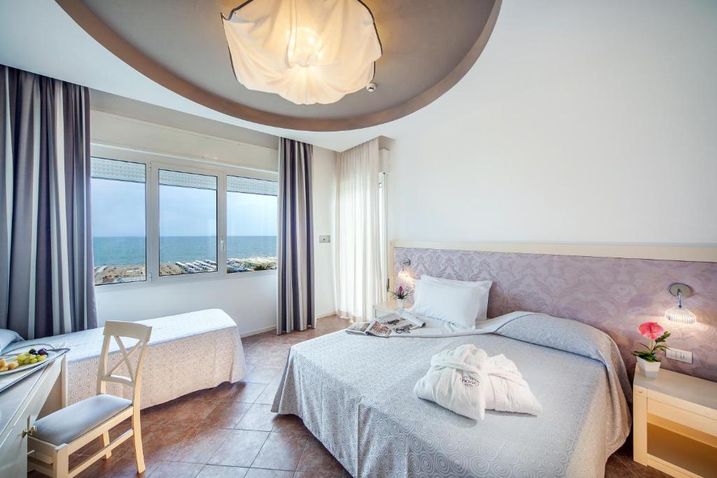 Cette chambre d'hôtel comprend deux lits et offre une vue sur l'océan. dans l'établissement Hotel Doge, à Milano Marittima