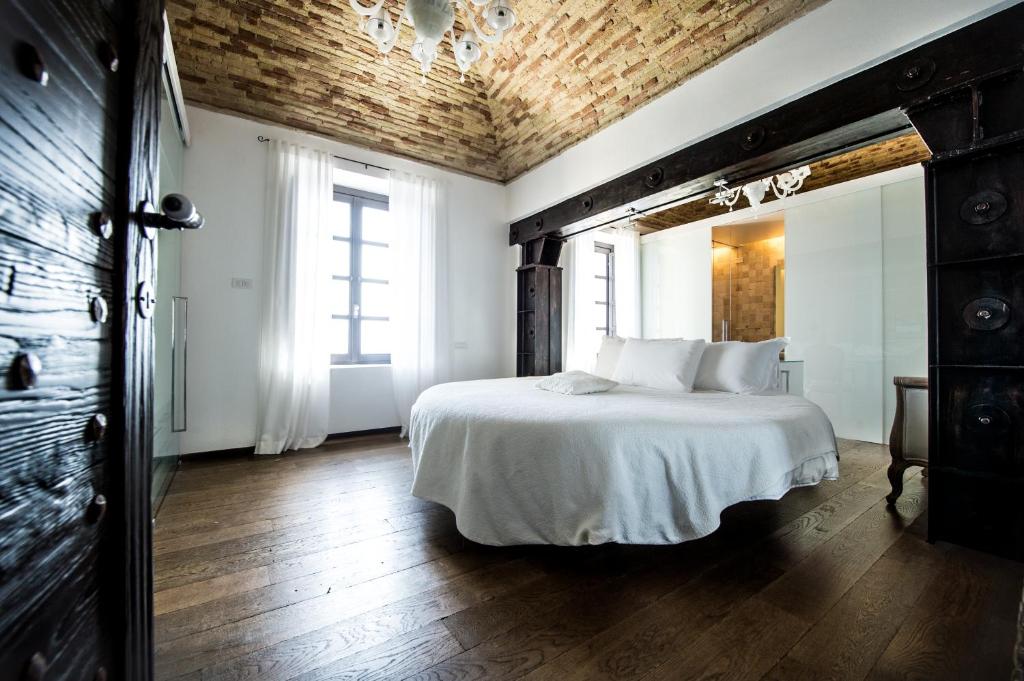 a bedroom with a white bed with a wooden ceiling at Faro Capo Spartivento in Chia