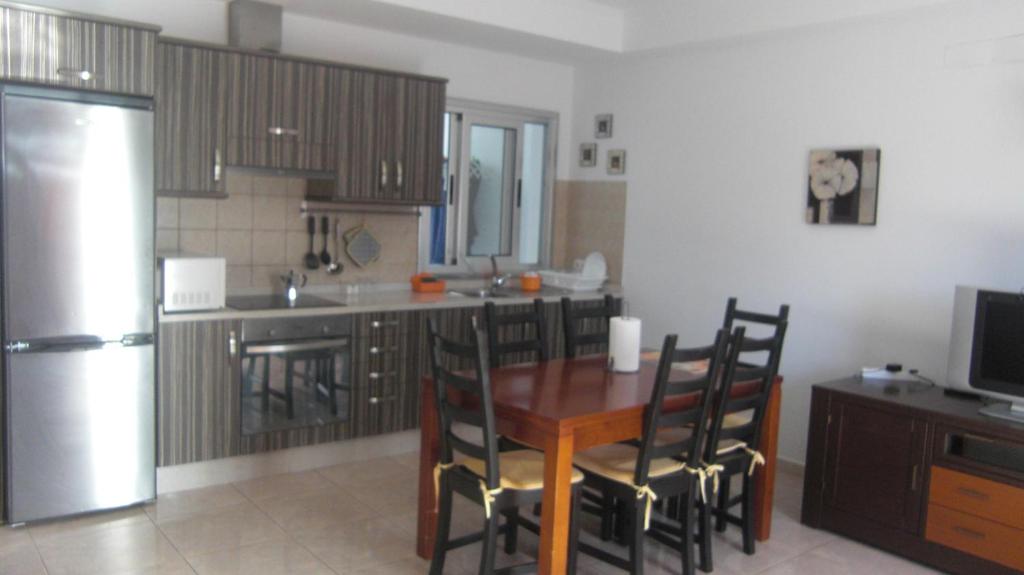グラン・タラハルにあるPISO 3 DORMITORIOS EN GRAN TARAJAL con wifiのキッチン(テーブル、椅子、冷蔵庫付)