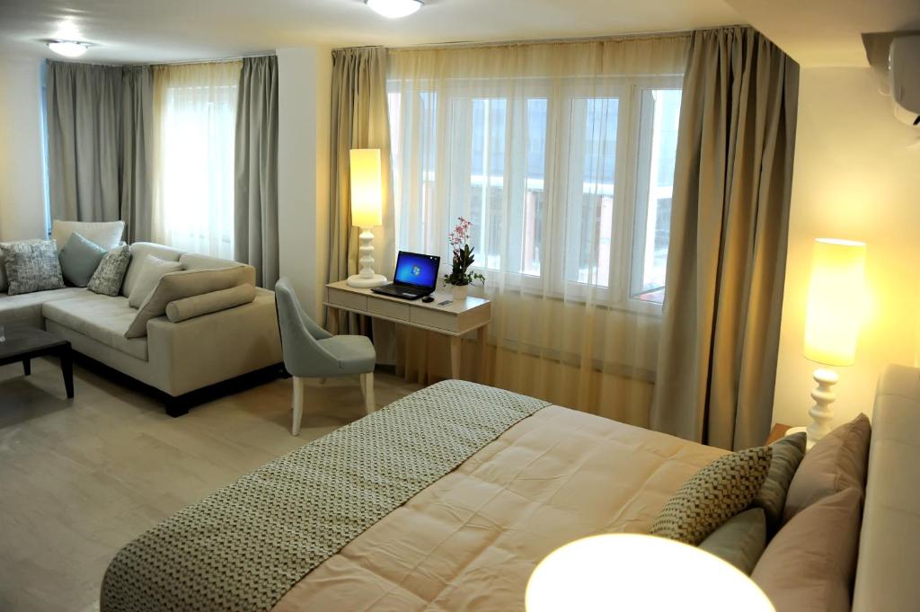 Habitación de hotel con cama y escritorio con ordenador portátil en GreeceRent - ELEGANT Center, en Tesalónica