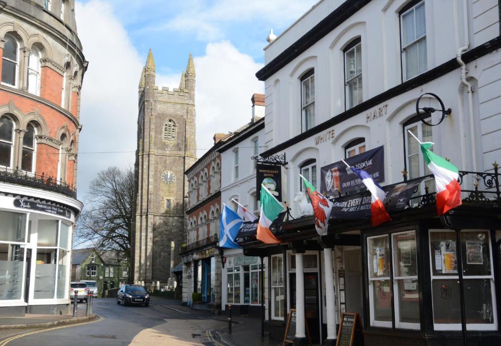 a street with a building with flags on it at The White Hart Hotel in Holsworthy