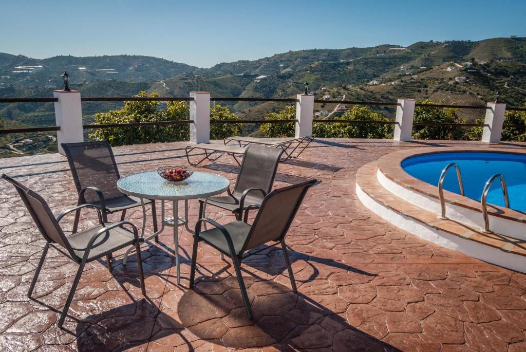 d'une terrasse avec une table et des chaises à côté de la piscine. dans l'établissement Casa Alba, à Frigiliana