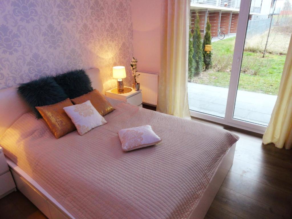 ein Schlafzimmer mit einem Bett mit Kissen und einem Fenster in der Unterkunft Na Grobli 014 in Breslau