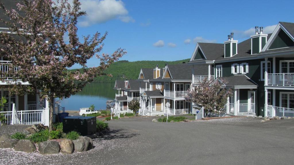 サン・ドナ・ド・モントカームにあるCondo Lac Archambault 326の湖を背景に並ぶ家屋