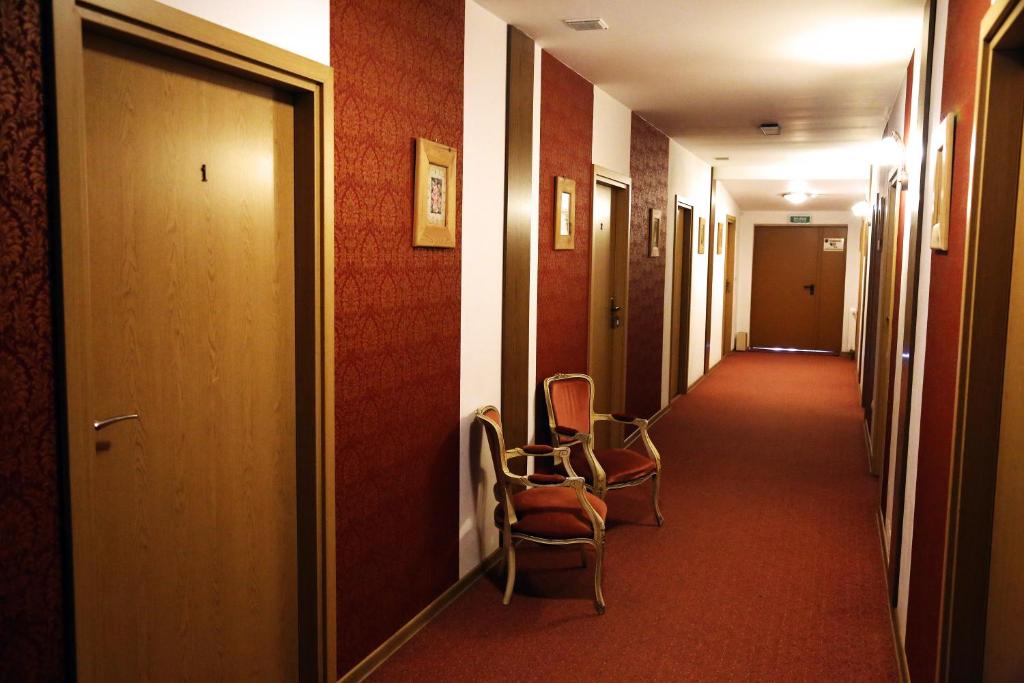 un pasillo con 2 sillas en una habitación de hotel en Zamek Camelot, en Dębica