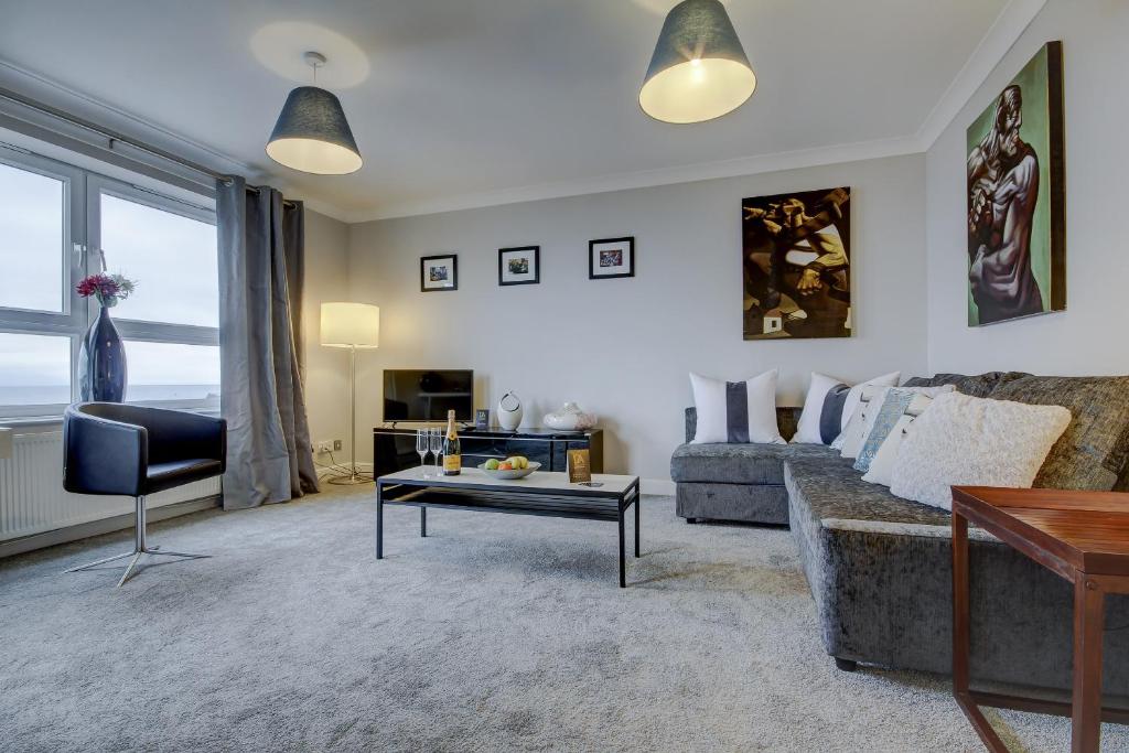 ein Wohnzimmer mit einem Sofa und einem Tisch in der Unterkunft Carrick Retreat - Donnini Apartments in Ayr