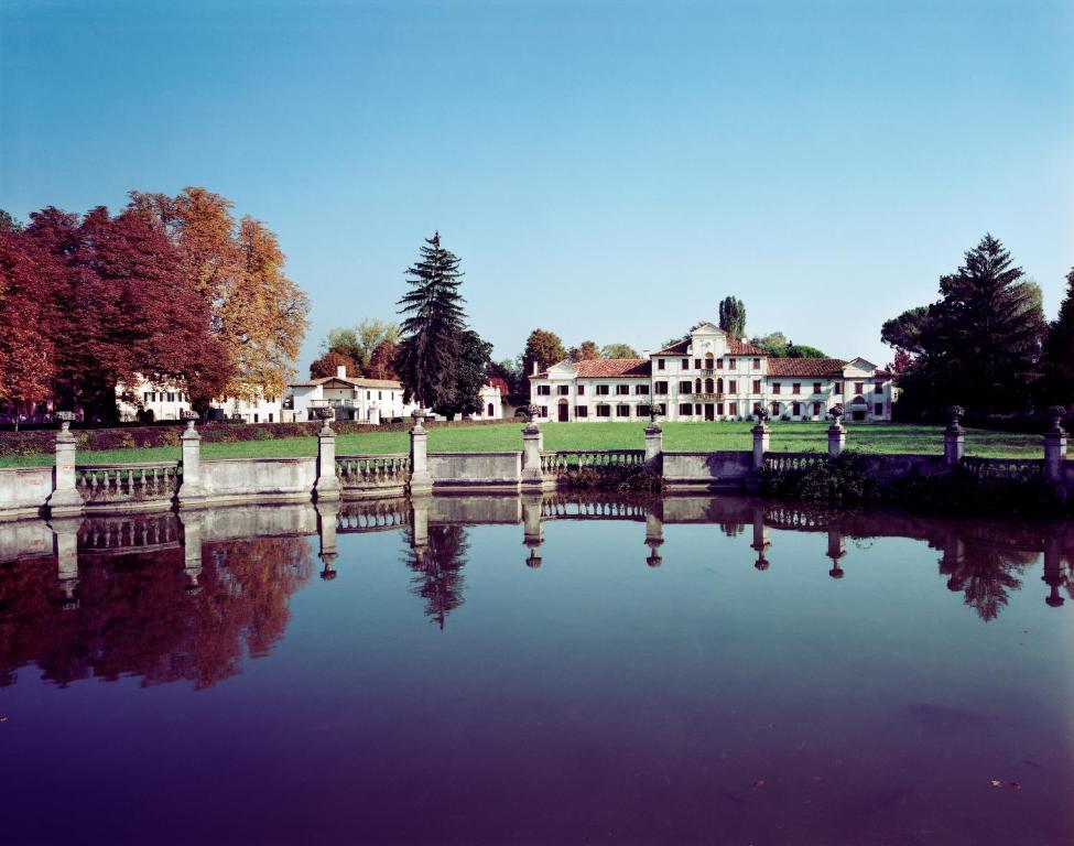 uma vista para um lago em frente a um edifício em Villa Toderini em Codognè