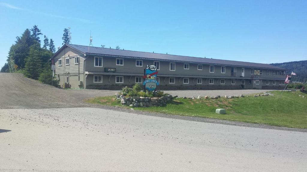a large building on a hill next to a road at Beluga Lake Lodge in Homer