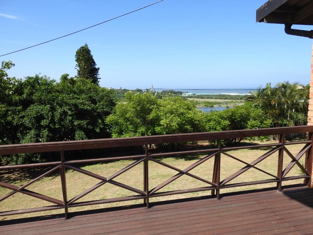 een houten terras met uitzicht op het water bij Rose of Sharon in Amanzimtoti