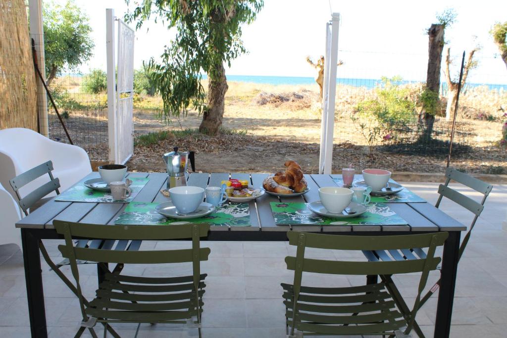 アルカモ・マリーナにあるAcquamarina House on the beachのテーブル(椅子付)、テーブル(食べ物付)