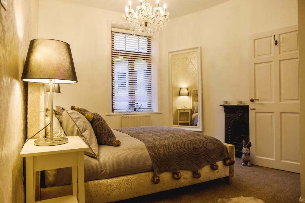 a bedroom with a bed with a lamp and a mirror at St John’s Cottage – Simple2let Serviced Apartments in Halifax