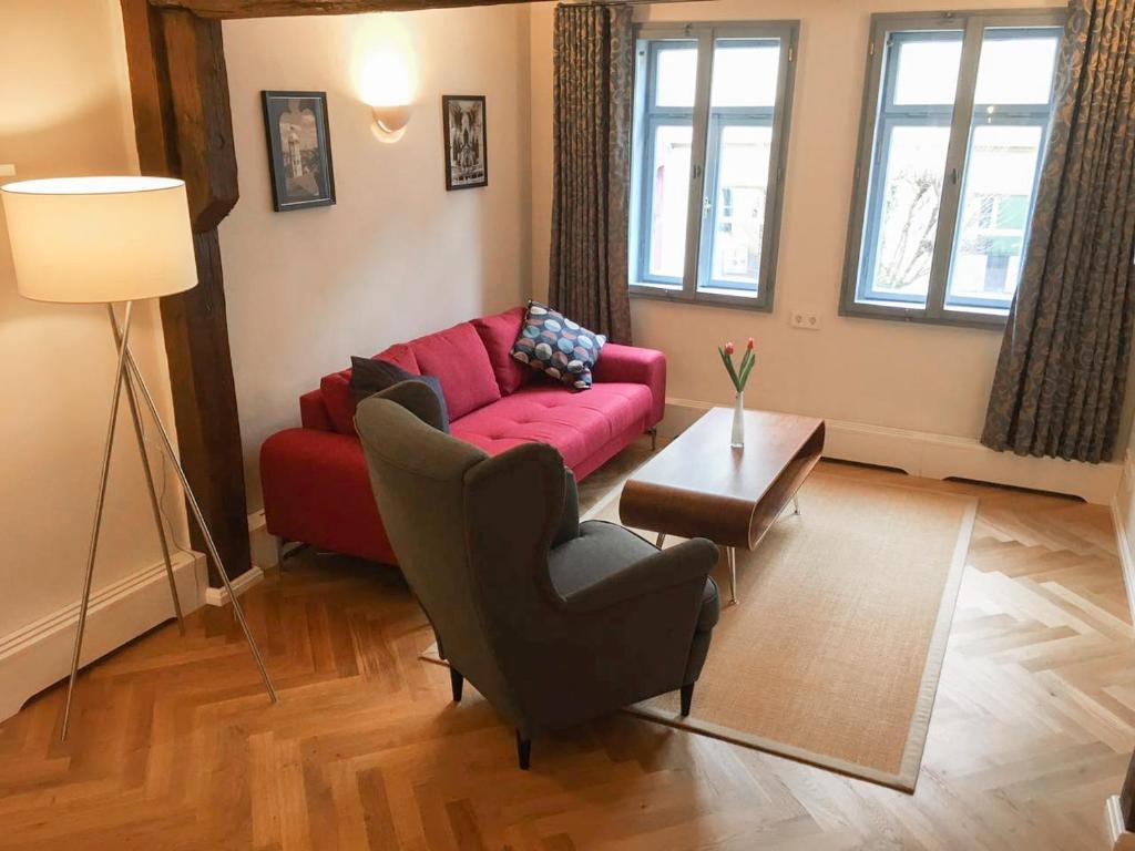 sala de estar con sofá rojo y mesa en Domizil Naumburg en Naumburg