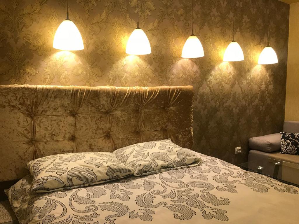 a bedroom with a bed with two pillows and two lights at Apartment near Dnipro Arena in Dnipro