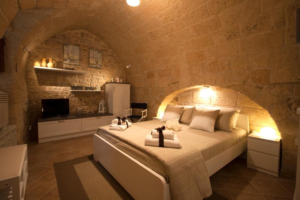 een slaapkamer met een groot bed in een stenen muur bij dormiRÈtrani in Trani