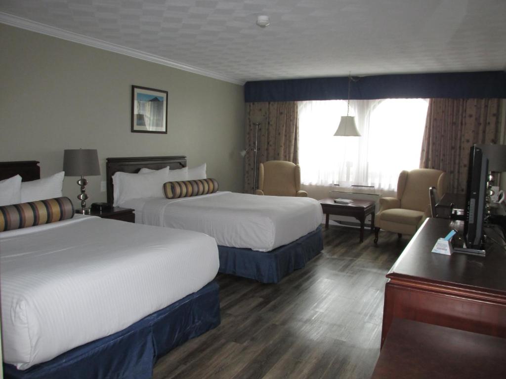 Postel nebo postele na pokoji v ubytování The Fredericton Inn